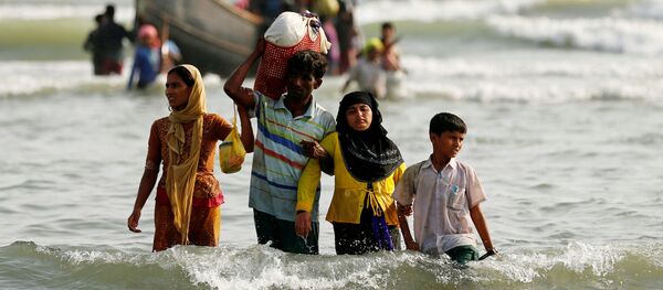 Dân tị nạn người Rohingya đổ lên bờ với đồ đạc của họ sau khi vượt biên giới đường biển giữa Bangladesh và Myanmar. - Sputnik Việt Nam