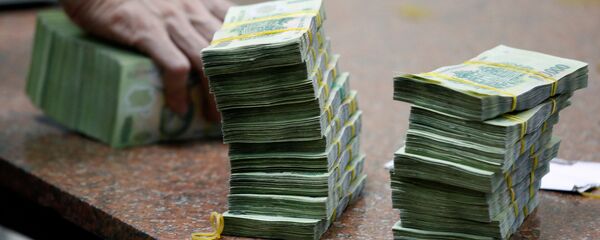 Сотрудник считает вьетнамские банкноты в филиале банка VietinBank в Ханое, Вьетнам - Sputnik Việt Nam