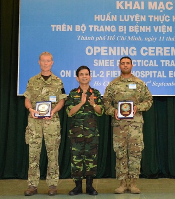 Đại tá Hoàng Kim Phụng, Giám đốc Trung tâm Gìn giữ hòa bình Việt Nam tặng quà lưu niệm các trưởng đoàn chuyên gia quân y của Hoa Kỳ và Vương quốc Anh. - Sputnik Việt Nam