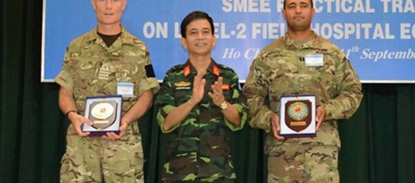 Đại tá Hoàng Kim Phụng, Giám đốc Trung tâm Gìn giữ hòa bình Việt Nam tặng quà lưu niệm các trưởng đoàn chuyên gia quân y của Hoa Kỳ và Vương quốc Anh. Đại tá Hoàng Kim Phụng, Giám đốc Trung tâm Gìn giữ hòa bình Việt Nam tặng quà lưu niệm các trưởng đoàn chuyên gia quân y của Hoa Kỳ và Vương quốc Anh. - Sputnik Việt Nam