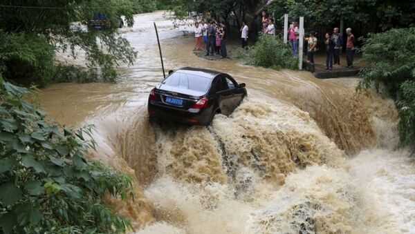 Chiếc ô tô mắc kẹt giữa lũ lụt sông tràn  bờ ở Trùng Khánh, Trung Quốc - Sputnik Việt Nam