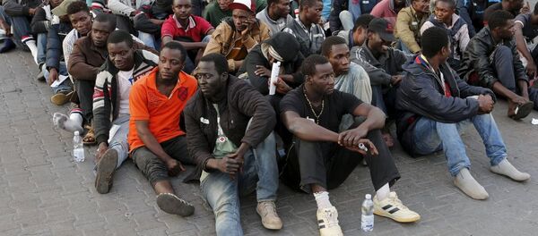 Người di cư từ Bắc Phi nghỉ ngơi sau khi được đưa lên tàu chiến của quân đội Anh HMS Bulwark tại cảng Catania - Sputnik Việt Nam