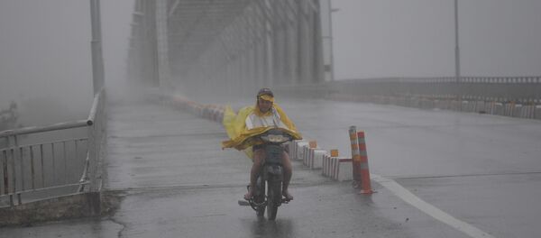 Cô gái Việt chạy xe trên con đường trống rỗng trong cơn bão “Doksuri”. - Sputnik Việt Nam