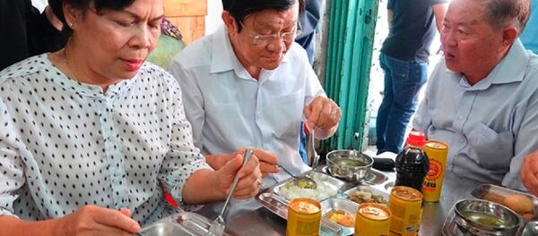 Nguyên Chủ tịch nước Trương Tấn Sang (giữa) và phu nhân ăn cơm 2.000 đồng tại Quán Nụ Cười 1 - Sputnik Việt Nam