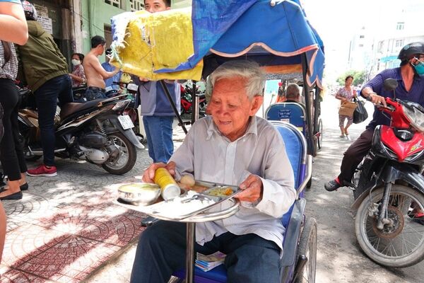Một người khuyết tật bán vé số đến nhận cơm - Sputnik Việt Nam