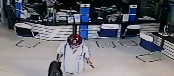 Kẻ cướp ung dung bước ra ngoài sau khi cướp trên 200 triệu đồng. Ảnh cắt ra từ camera an ninh - Sputnik Việt Nam