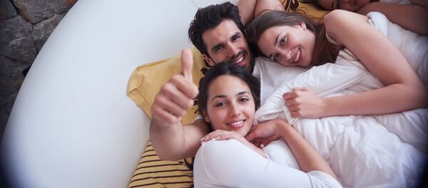 Мужчина в кровати в компании нескольких девушек - Sputnik Việt Nam