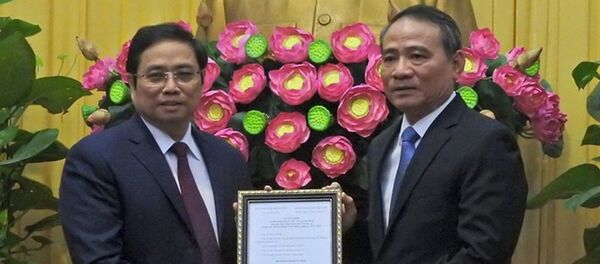 Ông Phạm Minh Chính, ủy viên Bộ Chính trị, trưởng Ban Tổ chức trung ương (trái) trao quyết định cho ông Trương Quang Nghĩa - Sputnik Việt Nam