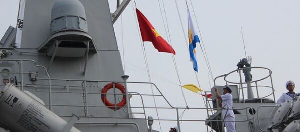 Thiếu tá Lê Đức Thảnh - thuyền trưởng tàu 383 - thực hiện nghi thức kéo quốc kỳ và cờ hải quân - Sputnik Việt Nam