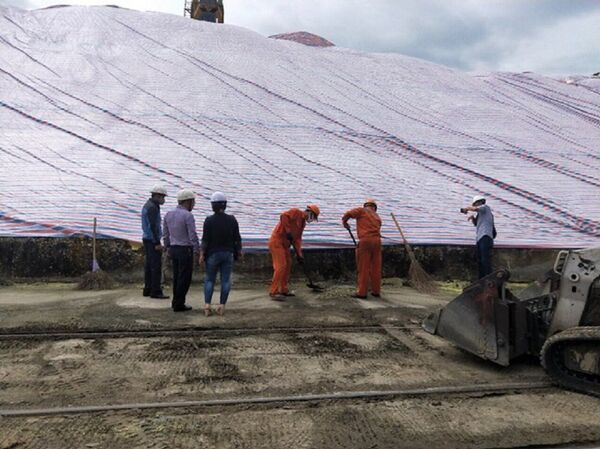 Cảng Hoàng Diệu phối hợp Công ty Cổ phần vận tải Traco I (chủ hàng) sử dụng bạt che và chặn quây dưới chân để ngăn không cho nước lẫn lưu huỳnh chảy xuống sông. - Sputnik Việt Nam