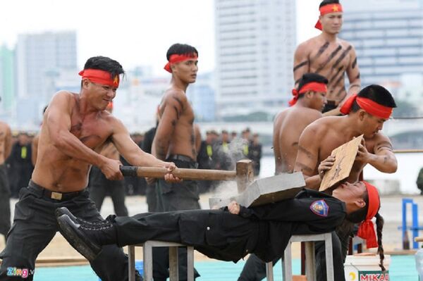 Màn biểu diễn để các đồng nghiệp nam dùng búa tạ đập vỡ đá tảng kê trên bụng của nữ chiến sĩ K20 - Sputnik Việt Nam