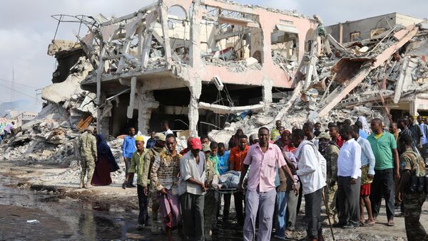 Civilians carry the body of an unidentified man from the scene of an explosion in KM4 street in the Hodan district of Mogadishu, Somalia October 15, 2017 - Sputnik Việt Nam