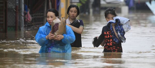 Những người đang vượt qua con đường ngập nước. Những người đang vượt qua con đường ngập nước. - Sputnik Việt Nam