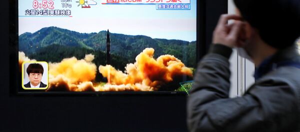 Трансляция новости о запуске северокорейской баллистической ракеты на одной из улиц Токио, Япония - Sputnik Việt Nam