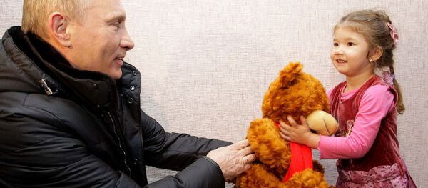 Ông Vladimir Putin khi là Thủ tướng Nga tặng con gấu bông cho bé gái ở Vùng Krasnodar, năm 2011 - Sputnik Việt Nam