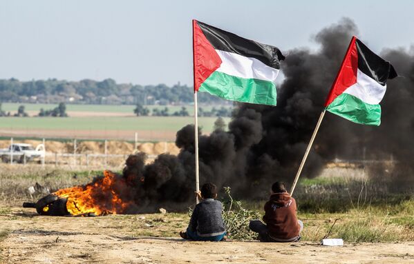 Người biểu tình Palestine mang lá cờ quốc gia ở ranh giới giữa Israel và Dải Gaza. - Sputnik Việt Nam