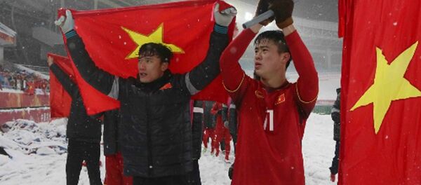 Duy Mạnh (phải) và lá cờ trước khi anh cắm trên sân Thường Châu. - Sputnik Việt Nam