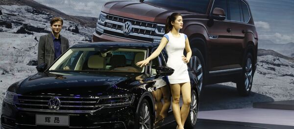 A female worker poses near cars from SAIC Volkswagen during the Auto Shanghai 2017 show at the National Exhibition and Convention Center in Shanghai, China, Thursday, April 20, 2017 - Sputnik Việt Nam