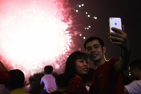 Đôi bạn trẻ cùng nhau chụp hình lưu lại kỷ niệm năm mới cùng với pháo hoa - Sputnik Việt Nam