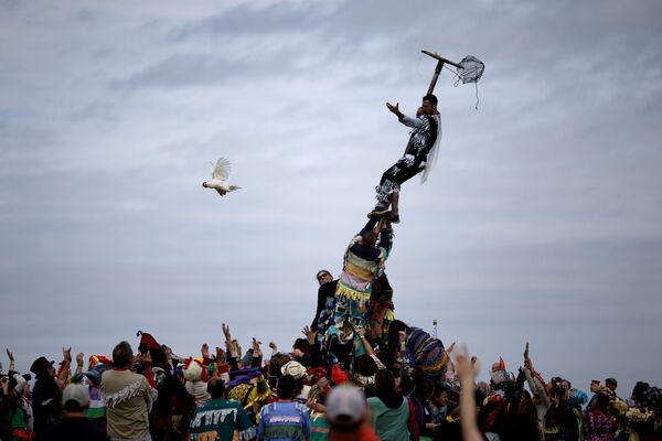 Một người tham gia Lễ hội Fequetaique Cheque de Mardi Gras ở Louisiana, Mỹ, thả chú gà mái ra khỏi lồng - Sputnik Việt Nam