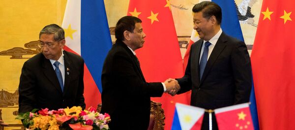 Philippine President Rodrigo Duterte and Chinese President Xi Jinping (R) shake hands after a signing ceremony held in Beijing, China, October 20, 2016 - Sputnik Việt Nam