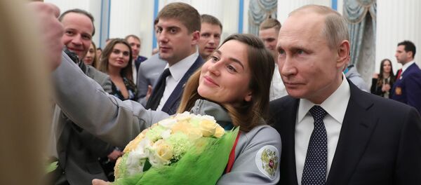 Tổng thống Nga Vladimir Putin cùng VĐV đoạt huy chương đồng trong cuộc thi trượt tuyết băng đồng Thế vận hội Olympic Mùa Đông ở Pyeongchang Julia Belorukova chụp ảnh sau lễ trao giải thưởng nhà nước cho các VĐV trong điện Kremlin - Sputnik Việt Nam