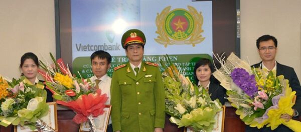 Thiếu tướng Nguyễn Thanh Hóa (đứng giữa), Cục trưởng Cục Cảnh sát Phòng chống tội phạm công nghệ cao trao Giấy khen cho 4 cá nhân thuộc Vietcombank. - Sputnik Việt Nam