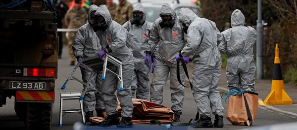 British Military personnel wearing protective coveralls work to remove a vehicle connected to the March 4 nerve agent attack in Salisbury, from a residential street in Gillingham, southeast England on March 14, 2018 British Military personnel wearing protective coveralls work to remove a vehicle connected to the March 4 nerve agent attack in Salisbury, from a residential street in Gillingham, southeast England on March 14, 2018 - Sputnik Việt Nam