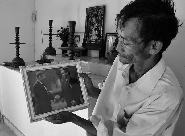 Ông Đỗ Ba và ảnh của hai người lính đã cứu mạng mình ngày 16/3/1968 - Sputnik Việt Nam