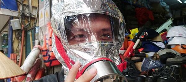 Một người dân đang thử mặt nạ chống khói trên phố Yết Kiêu. - Sputnik Việt Nam