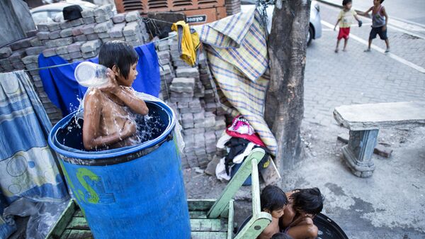 Trẻ em tắm trong thùng trên đường phố Manila - Sputnik Việt Nam