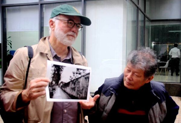 Nhà báo Kennerly với bức ảnh chụp bờ tường trại giam năm xưa. - Sputnik Việt Nam