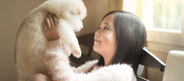 Cô bé châu Á với một chú cún con - Sputnik Việt Nam