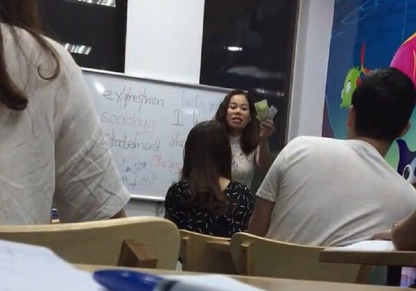 Cô Tuyến cầm tiền nộp phạt giơ lên trước lớp trong khi tranh cãi với học viên. Cô Tuyến cầm tiền nộp phạt giơ lên trước lớp trong khi tranh cãi với học viên. - Sputnik Việt Nam