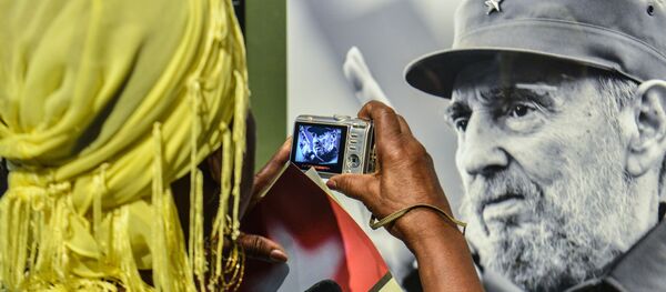 Một phụ nữ chụp bức ảnh chân dung cựu Chủ tịch Cuba Fidel Castro - Sputnik Việt Nam