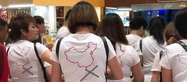 Nhóm khách Trung Quốc mặc áo in hình đường lưỡi bò nhập cảnh sân bay Cam Ranh. - Sputnik Việt Nam