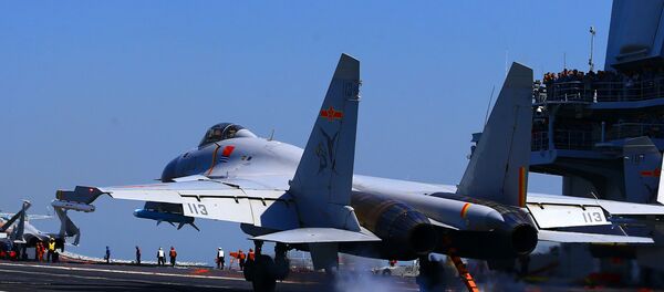 This photo taken on April 24, 2018 shows a J15 fighter jet landing on China's sole operational aircraft carrier, the Liaoning, during a drill at sea - Sputnik Việt Nam