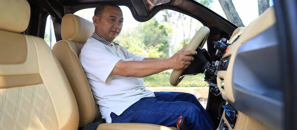 Ông Trần Minh Tâm kiểm tra thông số chiếc xe điện do mình chế tạo - Sputnik Việt Nam