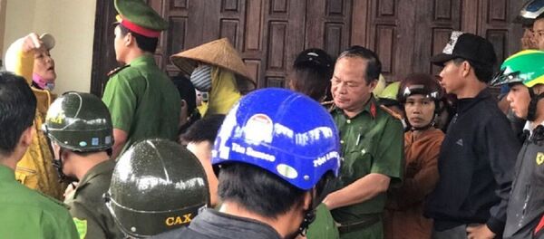 Trưởng Công an huyện Cư M'Gar cùng nhiều cán bộ đi cùng đã bị vợ ông Lương hắt chất bẩn vào người. - Sputnik Việt Nam