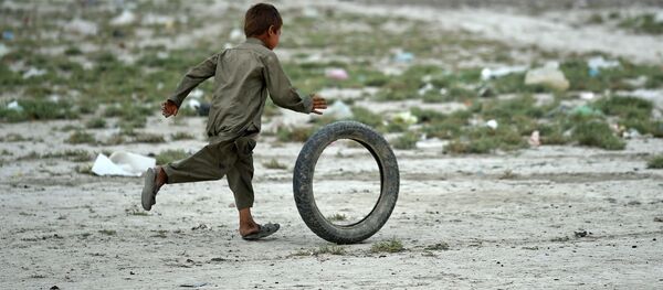 Cậu bé người Afghanistan chơi với lốp xe trong một khu trại của dân du mục, ngoại ô thủ đô Kabul. - Sputnik Việt Nam