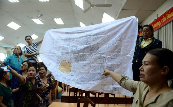 Một số người dân mang theo bản đồ quy hoạch 1/2.000 của khu đô thị mới Thủ Thiêm trưng trước hội trường ngày 9/5.  - Sputnik Việt Nam