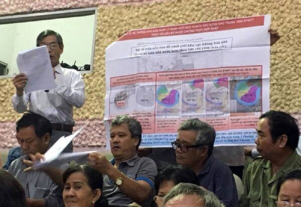 Người dân đưa ra tấm bản đồ quy hoạch Thủ Thiêm được Thủ tướng phê duyệt để đối chiếu với quy hoạch hiện tại.  - Sputnik Việt Nam