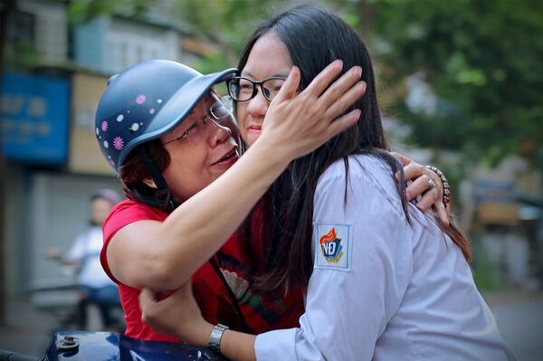 Động viên con vững tin trước giờ làm bài. Ảnh chụp sáng 25/6 tại điểm thi Trường THPT Việt Đức (Hà Nội). - Sputnik Việt Nam