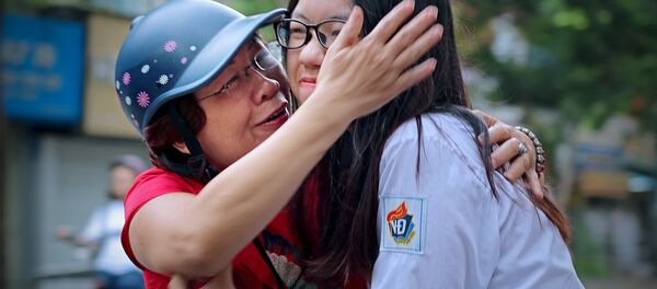 Động viên con vững tin trước giờ làm bài. Ảnh chụp sáng 25/6 tại điểm thi Trường THPT Việt Đức (Hà Nội). Động viên con vững tin trước giờ làm bài. Ảnh chụp sáng 25/6 tại điểm thi Trường THPT Việt Đức (Hà Nội). - Sputnik Việt Nam