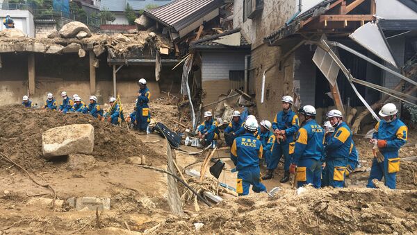 Những người cứu hộ đang nghỉ ngơi  gần những ngôi nhà bị tàn phá bởi mưa lớn ở Hiroshima, Nhật Bản - Sputnik Việt Nam