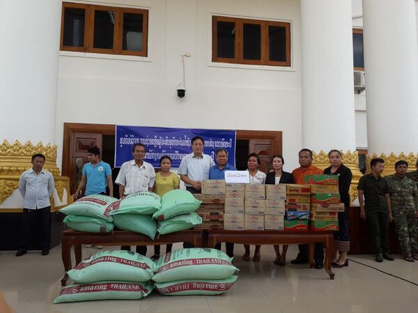 Ông Ngô Sĩ Quý (áo trắng, đứng giữa) chuyển hàng cứu hộ đến trung tâm tiếp nhận hàng cứu trợ tỉnh Attapeu - Sputnik Việt Nam