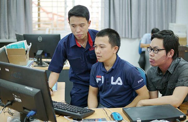 Nhóm sinh viên Nguyễn Thế Đức và Hồ Văn Chương đang được kỹ sư Tạ Quốc Việt (người đứng) hướng dẫn hoàn thiện sản phẩm. - Sputnik Việt Nam