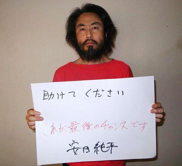 This undated picture provided by Japan's Jiji Press news agency, taken at an undisclosed location, on May 30, 2016 shows Japanese freelance journalist Jumpei Yasuda holding a piece of paper with a handwritten message in Japanese. The fresh photo, which received widespread coverage in Japanese media on May 30, 2016, shows Yasuda, who has been missing for almost a year, wearing an orange shirt, his hair and beard grown long. This undated picture provided by Japan's Jiji Press news agency, taken at an undisclosed location, on May 30, 2016 shows Japanese freelance journalist Jumpei Yasuda holding a piece of paper with a handwritten message in Japanese. The fresh photo, which received widespread coverage in Japanese media on May 30, 2016, shows Yasuda, who has been missing for almost a year, wearing an orange shirt, his hair and beard grown long. - Sputnik Việt Nam