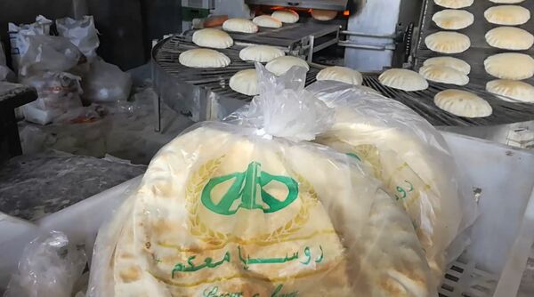 Trên đường phố Aleppo thường có thể thấy người dân cầm trong tay những chiếc túi in dòng chữ Nước Nga cùng với bạn. - Sputnik Việt Nam