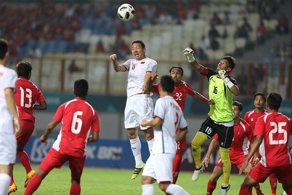 Anh Đức bật cao đánh đầu trước vòng vây của hậu vệ Olympic Nepal.  - Sputnik Việt Nam